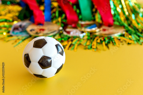 World Cup, soccer ball and medals on yellow background