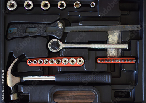 Vista superior de herramientas de trabajo usadas, copas, maneral, sierra, martillo y puntas para destornillador. photo