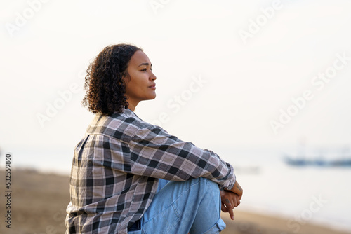 Woman sitting in solitude by the sea photo