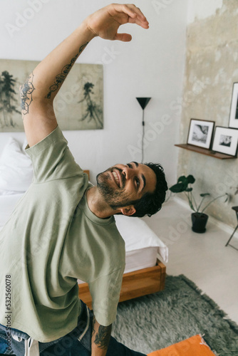 Smiling Young Man Doing Yoga At Home photo