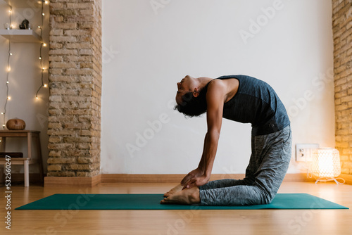 Man performing Camel asana during yoga class photo