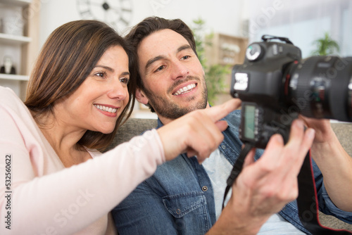 happy couple looking at photos on camera screen