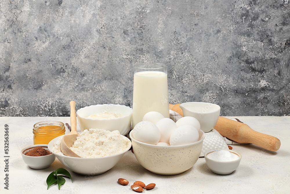 Kitchen background for baking and making cake,bread,confectionery and ingredients for cooking,milk,honey,flour,salt,sugar,eggs and cream on concrete background Kitchen background for baking and making cake,bread,confectionery and ingredients for cooking,milk,honey,flour,salt,sugar,eggs and cream on concrete background