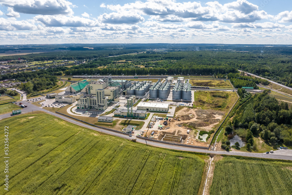 aerial view on rows of agro silos granary elevator with seeds cleaning line on agro-processing manufacturing plant for processing drying cleaning and storage of agricultural products