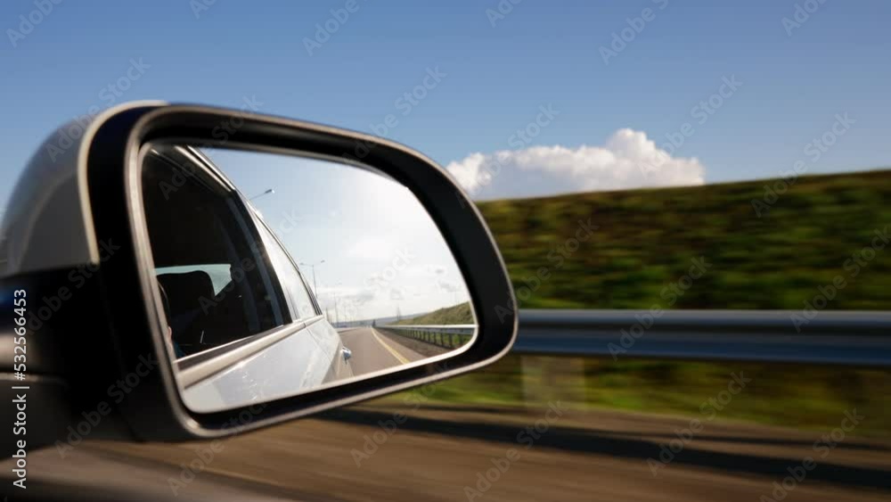 View from of the Side Mirror the Inside of a Driving Car Along the Highway in a Sunny Day. Concept of Vehicles and Transport. No People. View from of the Side Mirror the Inside of a Driving Car Along the Highway in a Sunny Day. Concept of Vehicles and Transport. No People.