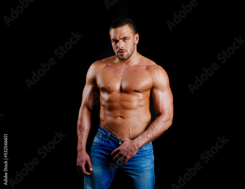 Muscular sexy guy with naked torso. Portrait of strong healthy handsome athletic man fitness model posing on black. Sexy man. Seductive face of a sexy man. Sexy naked torso, six pack abs.