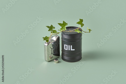 Steel canister with growing plant and oil barrel. photo
