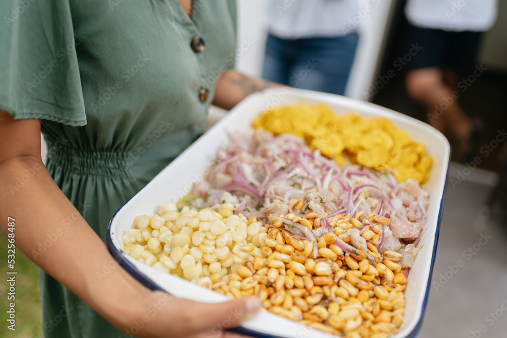 Close-up of hands holding a platter of ceviche Close-up of hands holding a platter of ceviche