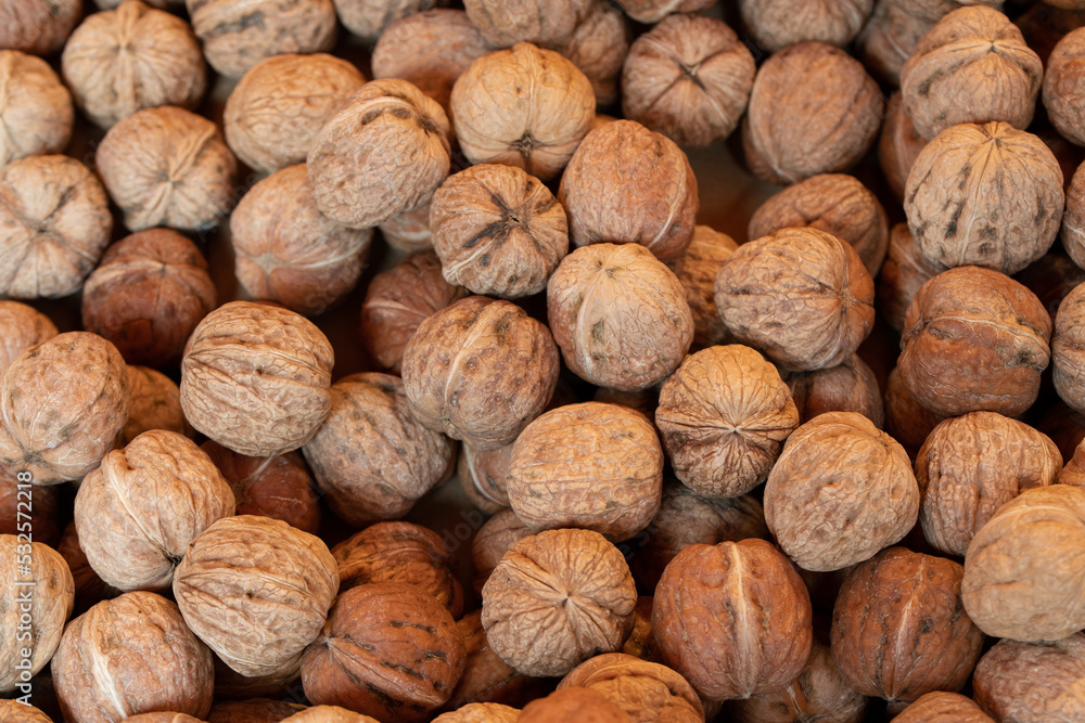 Texture with lots of walnuts, all lying next to each other with their shell still on. Texture with lots of walnuts, all lying next to each other with their shell still on.