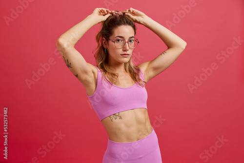 Confident young fit lady looking at camera in studio photo