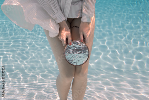 Woman with mirror underwater photo