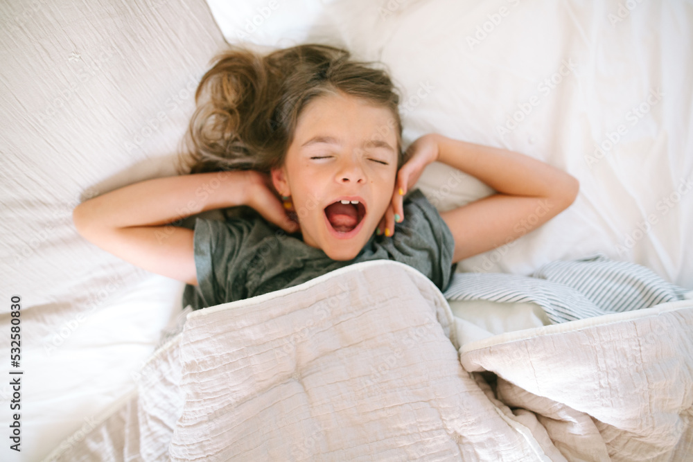 Overhead view of young girl waking up in the morning Overhead view of young girl waking up in the morning