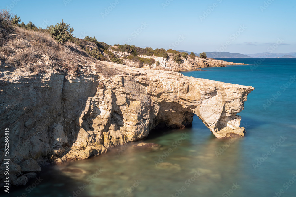 Long exposure photography of a famous rock formation in alacati, at sunset light the rocks glowing and with clouds and blue sky