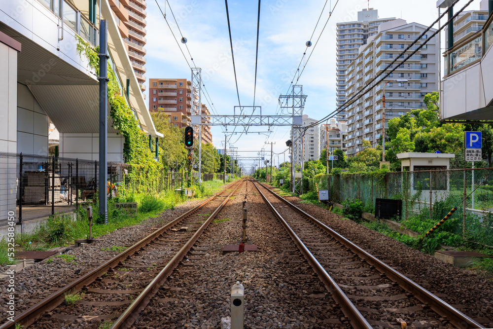 都市の建物の間の電車の線路 都市の建物の間の電車の線路