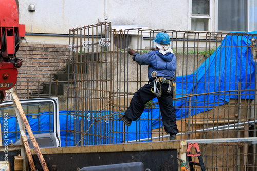 建物の基礎の鉄筋を組む男性作業員 © captainT