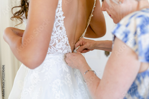 Mother Buttoning the Back of a Wedding Dress photo