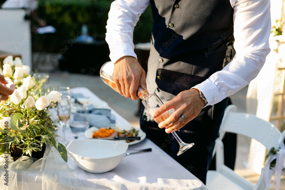 Closeup of Groom Pouring Sparkling Rose Wine into Glass Closeup of Groom Pouring Sparkling Rose Wine into Glass