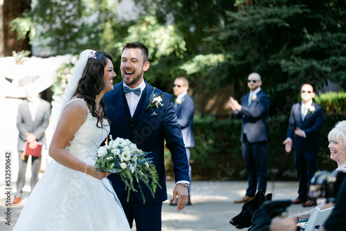 A Bride and Groom Laugh and Smile after their Wedding Ceremony photo