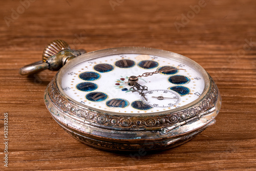 Ornate antique silver pocket watch with decorative dial and patina photo