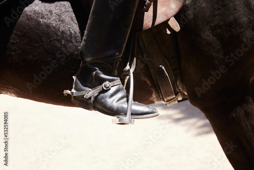 Rider's boot sitting in a horse stirrup  photo