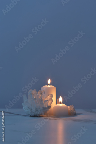 Shiny quartz crystals with candles burning in dark
