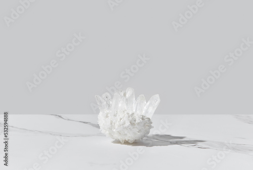 Healing white quartz crystal on marble background photo