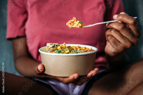 Unrecognizable woman eating poke bowl photo