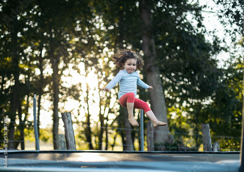 Wallpaper Mural Little girl jumping on a trampoline Torontodigital.ca
