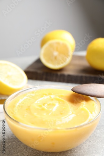 Delicious lemon curd in bowl on grey table. Space for text