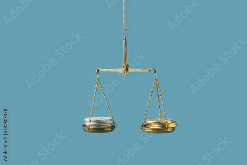 Silver and golden coins on justice scales. photo