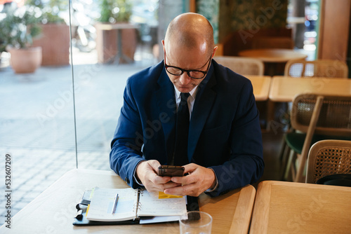 Businessman texting on cellphone during work
