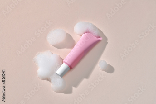 Pink tube with gel or face cream with a white cap on a background photo