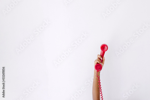 Woman showing red telephone handset photo