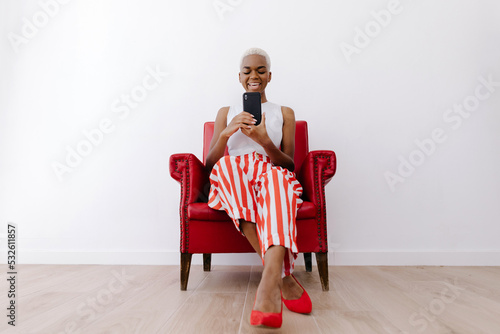 Cool black lady using smartphone and laughing photo