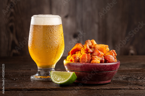 Pork rinds (torresmo) with beer, typical Brazilian food. photo
