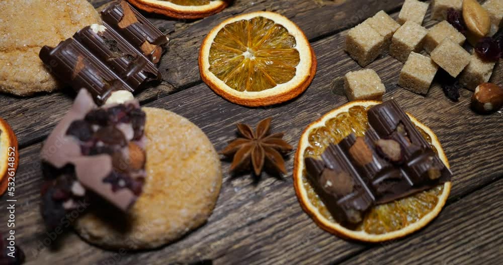 Natural composition in hygge style with orange slices, fragrant spices, chocolate, shortbread, nuts on an old vintage wooden board background. Natural composition in hygge style with orange slices, fragrant spices, chocolate, shortbread, nuts on an old vintage wooden board background.