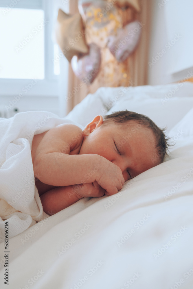 Infant resting on bed balloons behind Infant resting on bed balloons behind