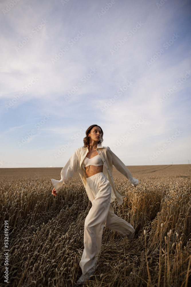 Female model in sleeping suit moving in empty field Female model in sleeping suit moving in empty field