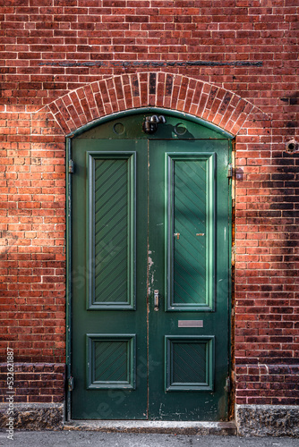 A green front door of the old brick building