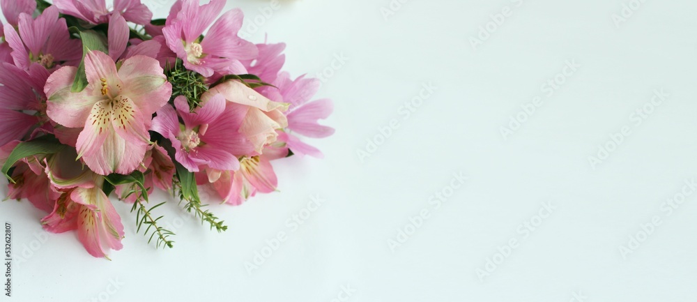 Bouquet of pink alstroemeria on a white background. A delicate festive composition. Background for a greeting card.