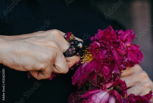 Anonymous woman ripping petals of bright flower - agression - emotion photo