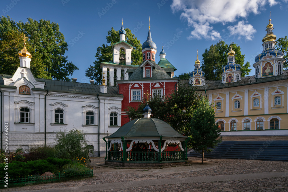 Sretensky Church, Assumption Cathedral, the Great Bell Tower, the sacristy and the holy well of the Holy Dormition Pskov-Pechersk Monastery on a sunny summer day, Pechory, Pskov region, Russia