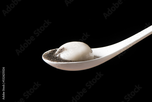 glue pudding or tangyuan with black sesame on black background photo