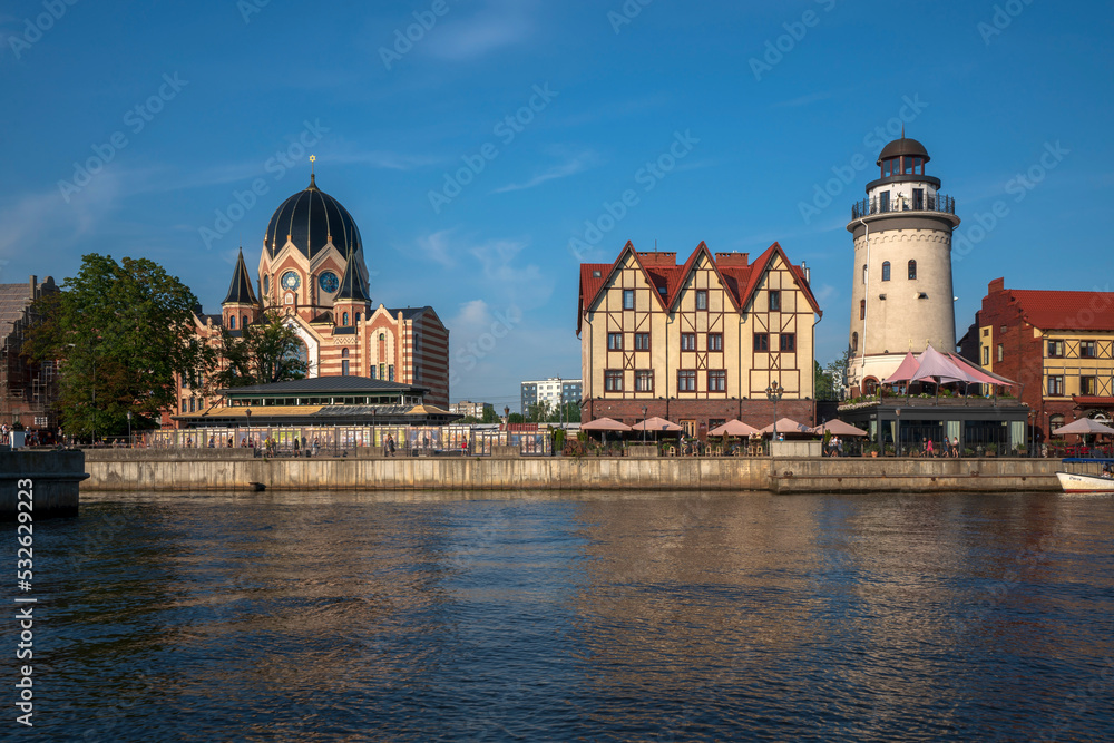 View of the embankment of the Pregolya River, the Fishing village, the Konigsberg Lighthouse, the New Kaliningrad Synagogue on a sunny summer day, Kaliningrad, Russia