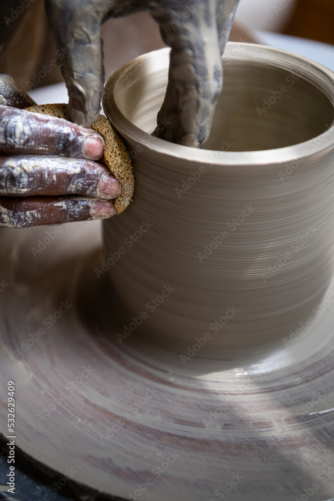 Closeup of woman working with clay on the pottery wheel Closeup of woman working with clay on the pottery wheel
