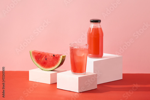 A glass of watermelon juice surrounded with a slice red photo