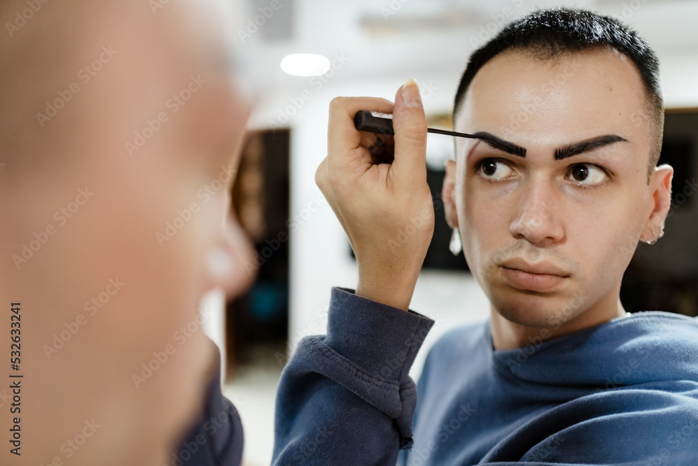 Man painting his eyebrows Man painting his eyebrows