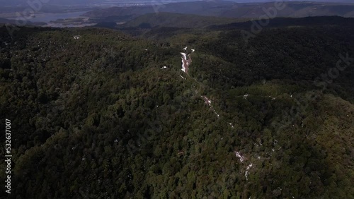 Aerial pan out video of road in the middle of the mountains with the coast in the back, landscape in Oncol Park in Chile. photo