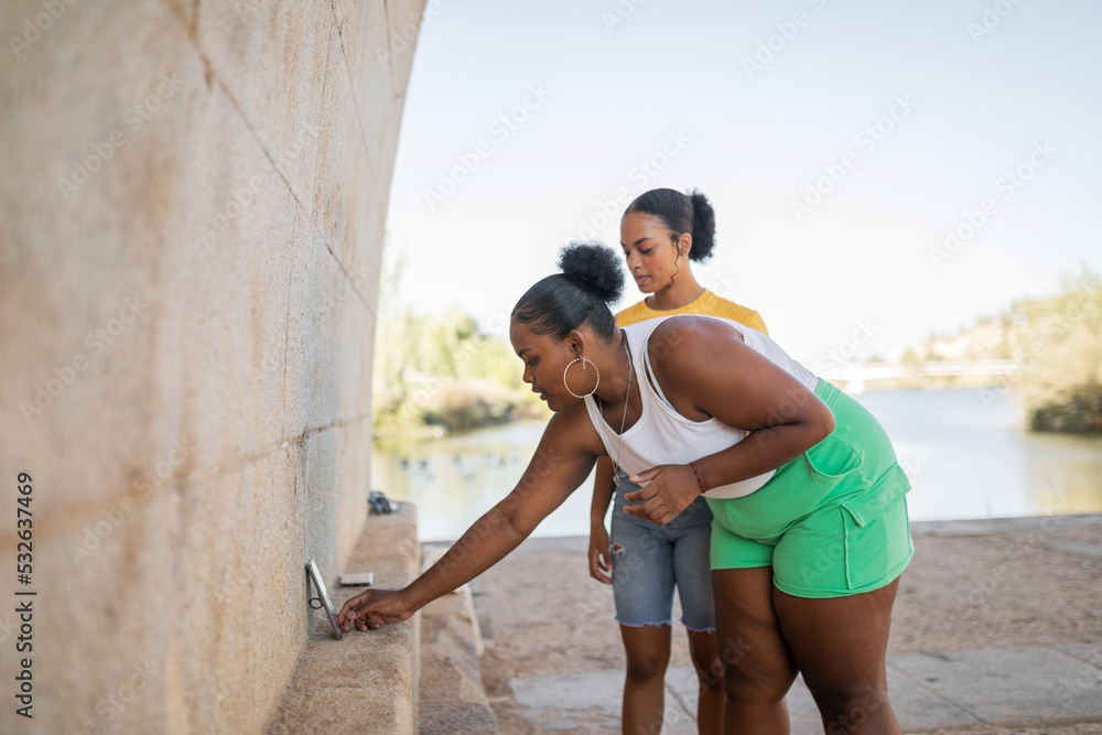 black women friends dancing in front of their mobile phone black women friends dancing in front of their mobile phone