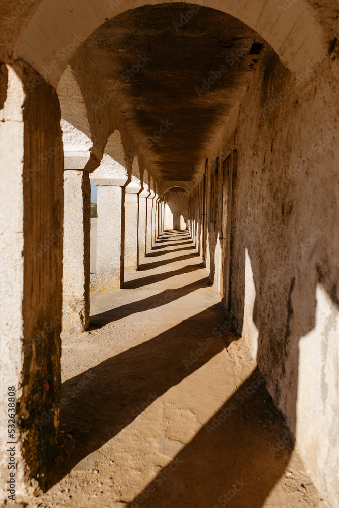 © Tania Cervian/Stocksy - Arched pathway outside old building
